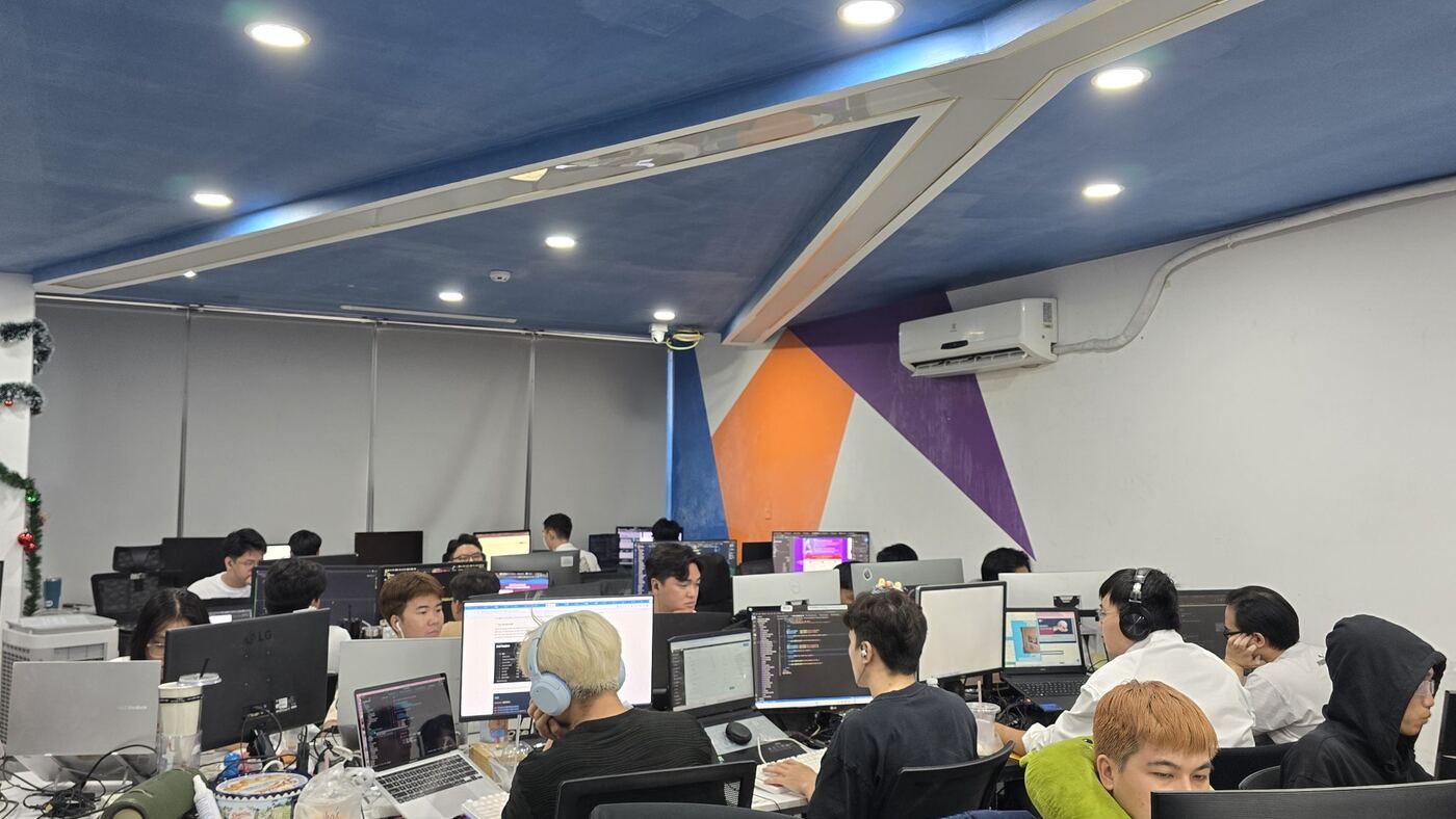 Sàn văn phòng MONA trần xanh, đội ngũ làm việc bên dãy màn hình